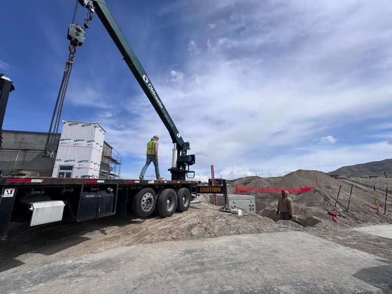 Omega Line Construction crew working with a crane truck on a job site